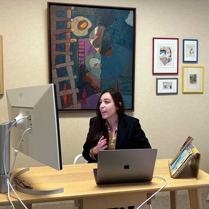 Lynn Zovighian at The Zovighian Public Office in Beirut. She is in a blazer at her desk, looking at a computer screen.