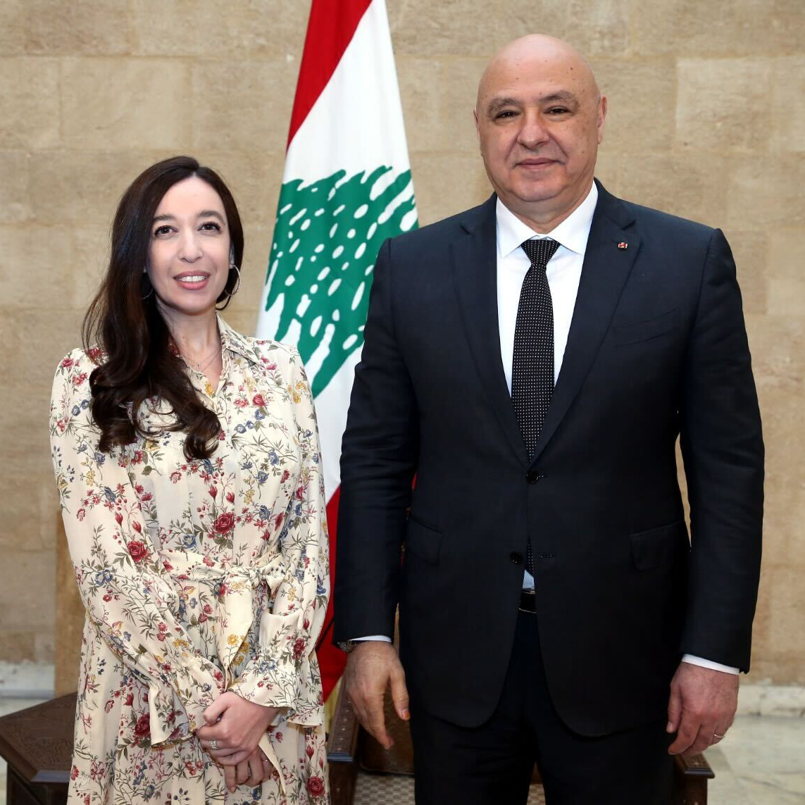 Lynn Zovighan & President Joseph Aoun stand before the Lebanese flag at presidential Baabda Palace.