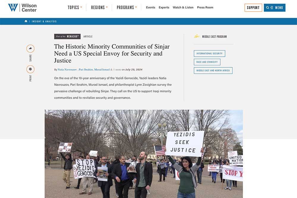 Article from the Wilson Center website. People protesting holding American flags & signs that read: