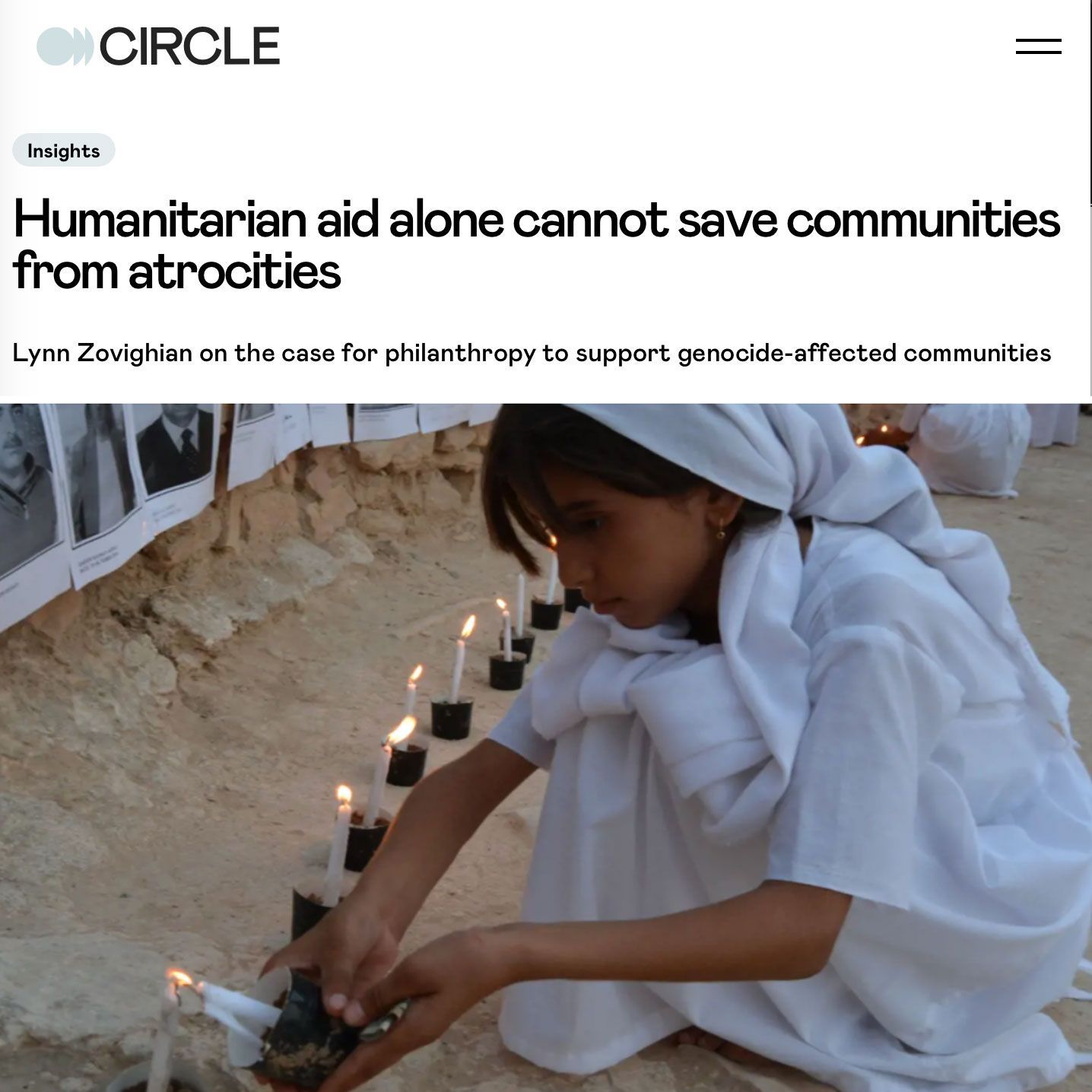 A girl in white lighting candles near photos on wall Headline: Humanitarian aid alone cannot save communities from atrocities