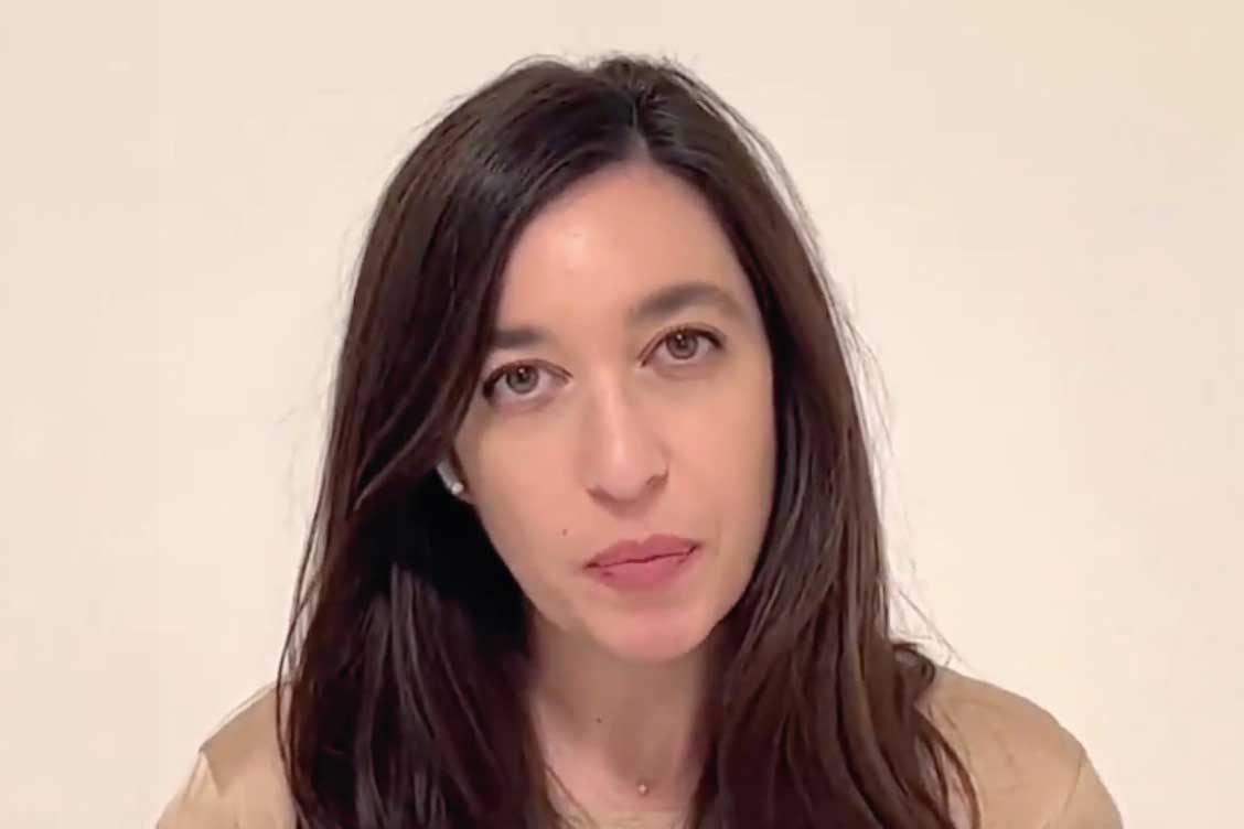 Lynn Zovighian with long brown hair looks towards the camera. She's wearing a light-colored top. Plain white background.