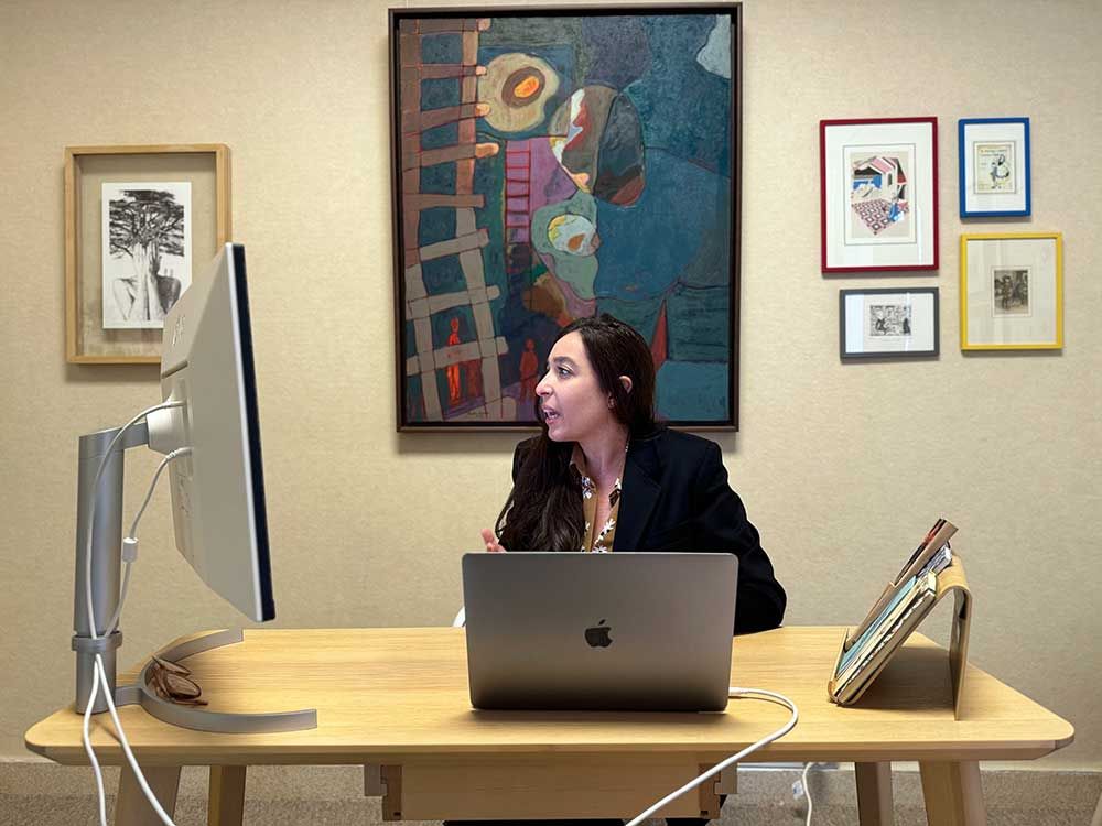 Lynn Zovighian at The Zovighian Public Office in Beirut. She is in a blazer at her desk, looking at a computer screen.