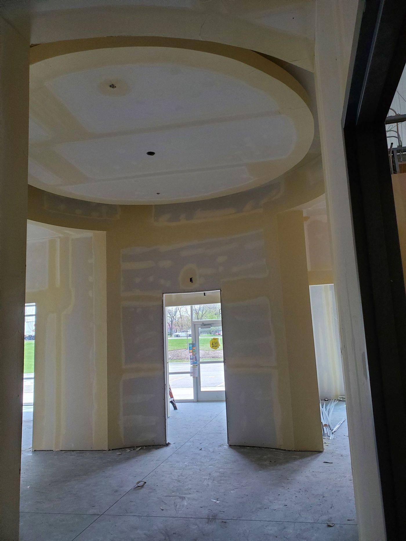 An empty room with a circular ceiling and a door.