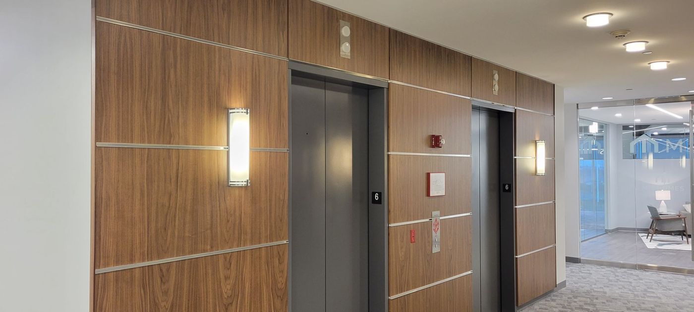 There are two elevators in the hallway of a building.