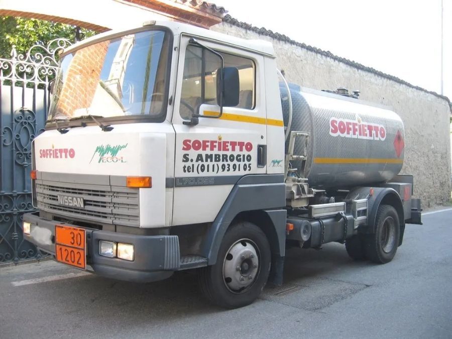 Un'autocisterna bianca per carburante parcheggiata in strada con il marchio 