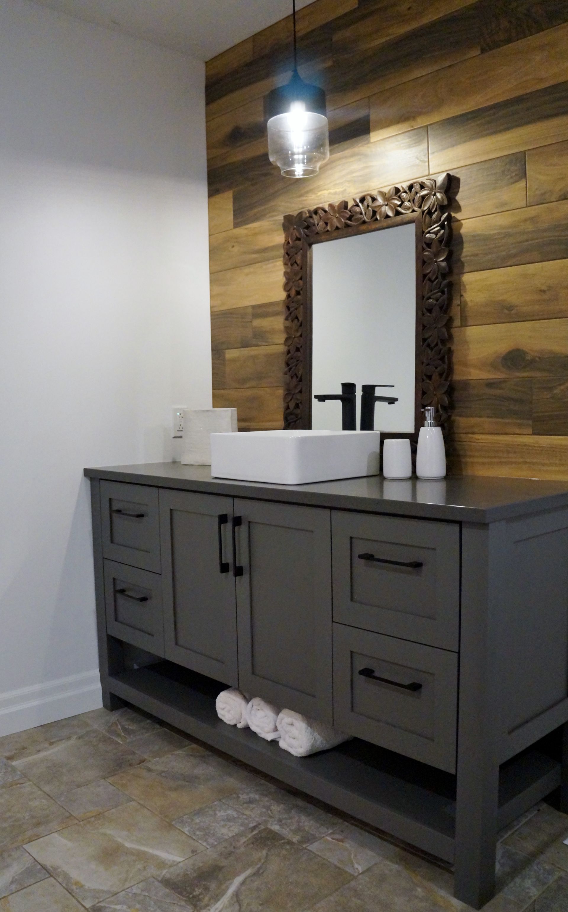 Une salle de bain avec un lavabo, un miroir et des armoires