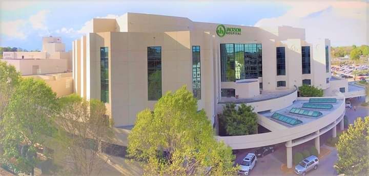 An aerial view of a large building with cars parked in front of it.