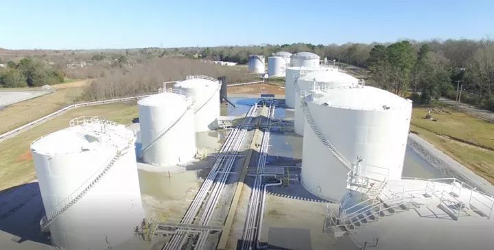 An aerial view of a row of large white tanks.