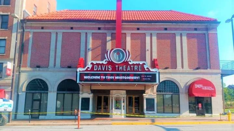 Davis Theatre exterior with red marquee, brick facade, and arched windows.