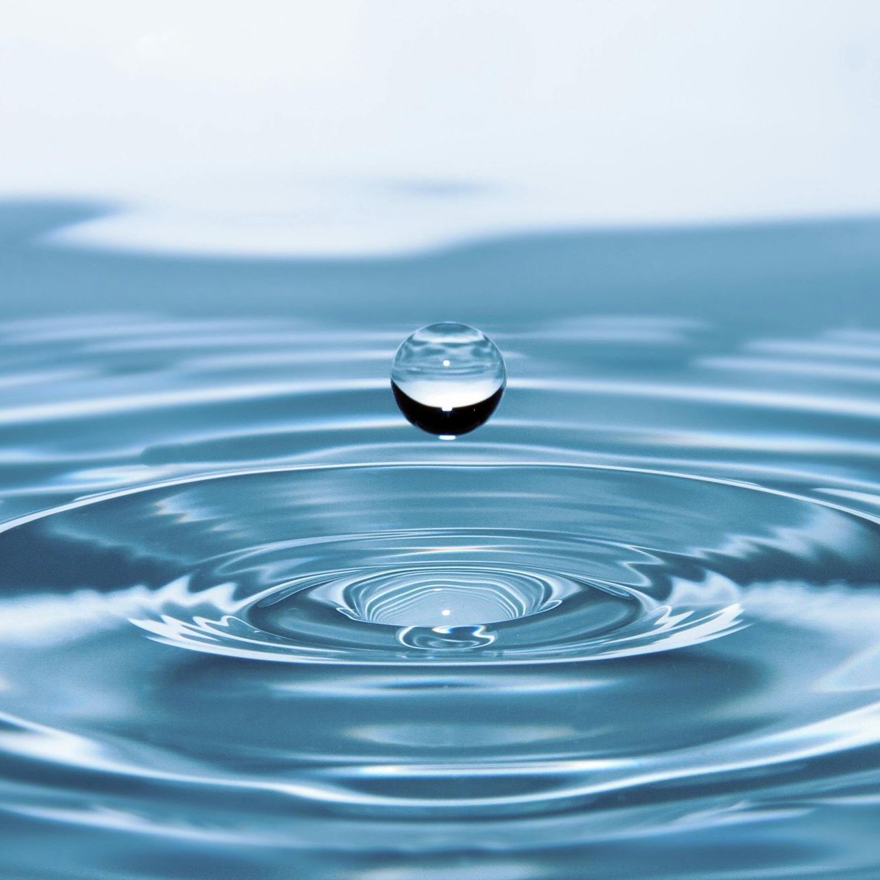 A drop of water is falling into a pool of water