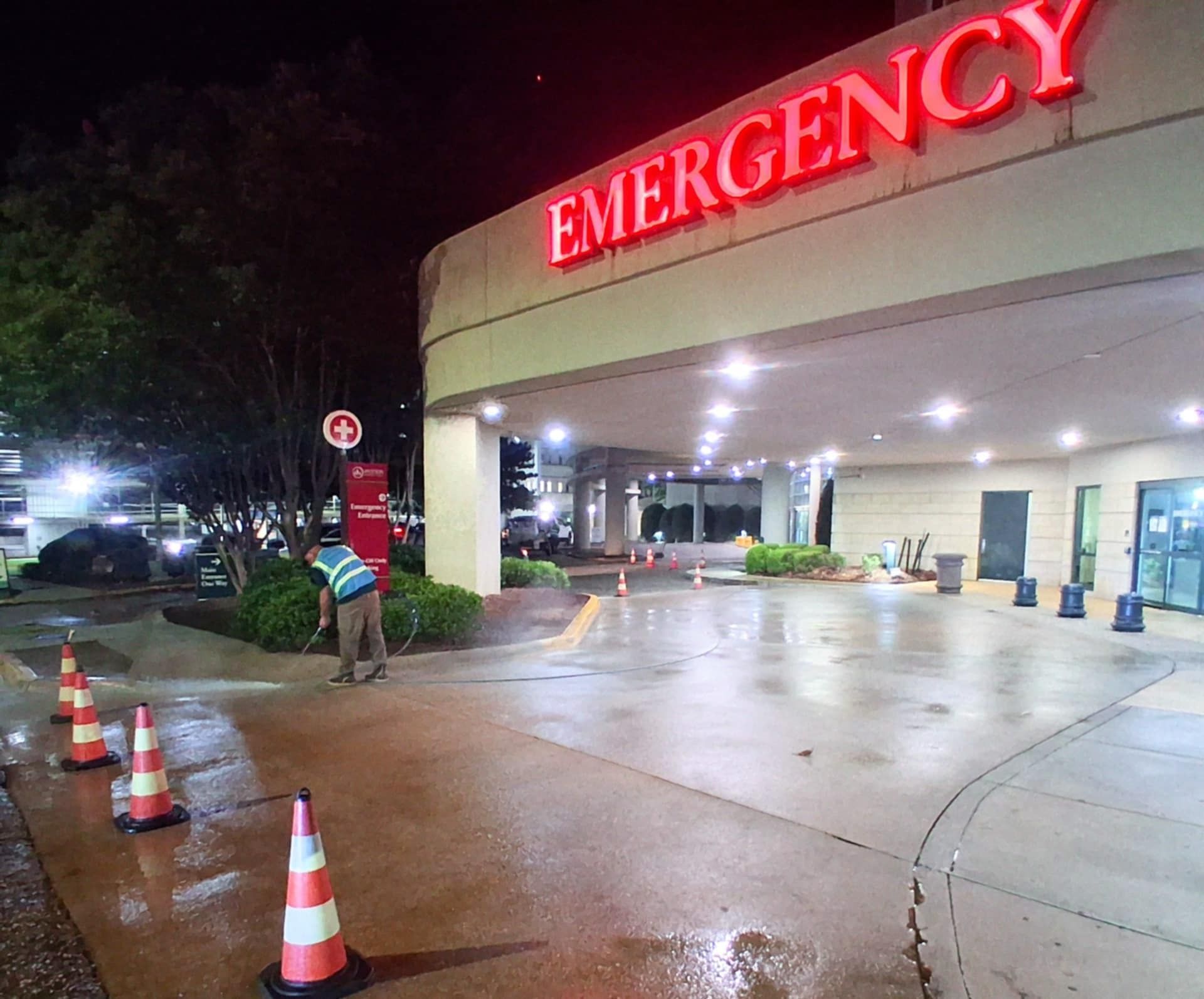 Pressure washing hospital entrance at night