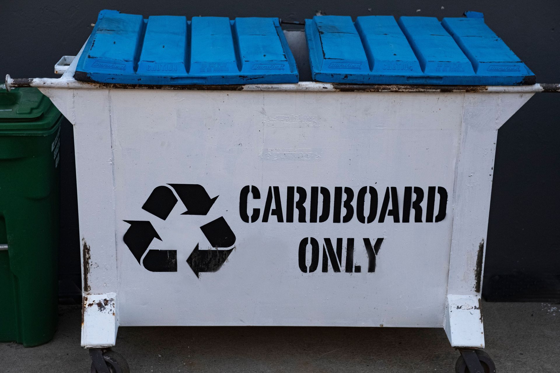 White recycling bin with blue lid labeled “CARDBOARD ONLY” and a recycle symbol.