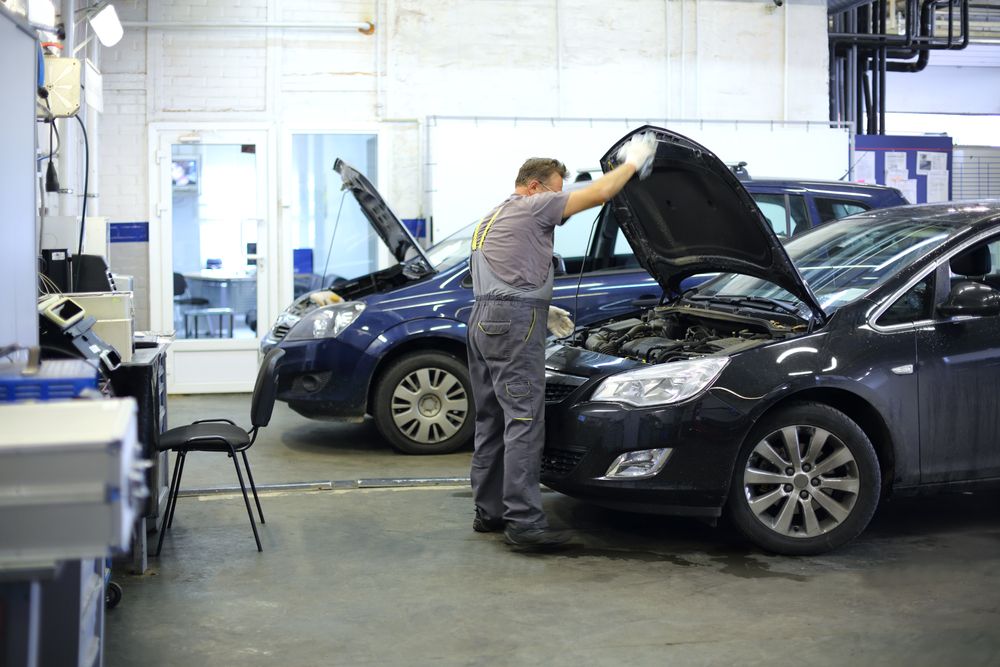 A Man is Working on a Car in a Garage With the Hood Open — Ballina Automatics in Ballina, NSW