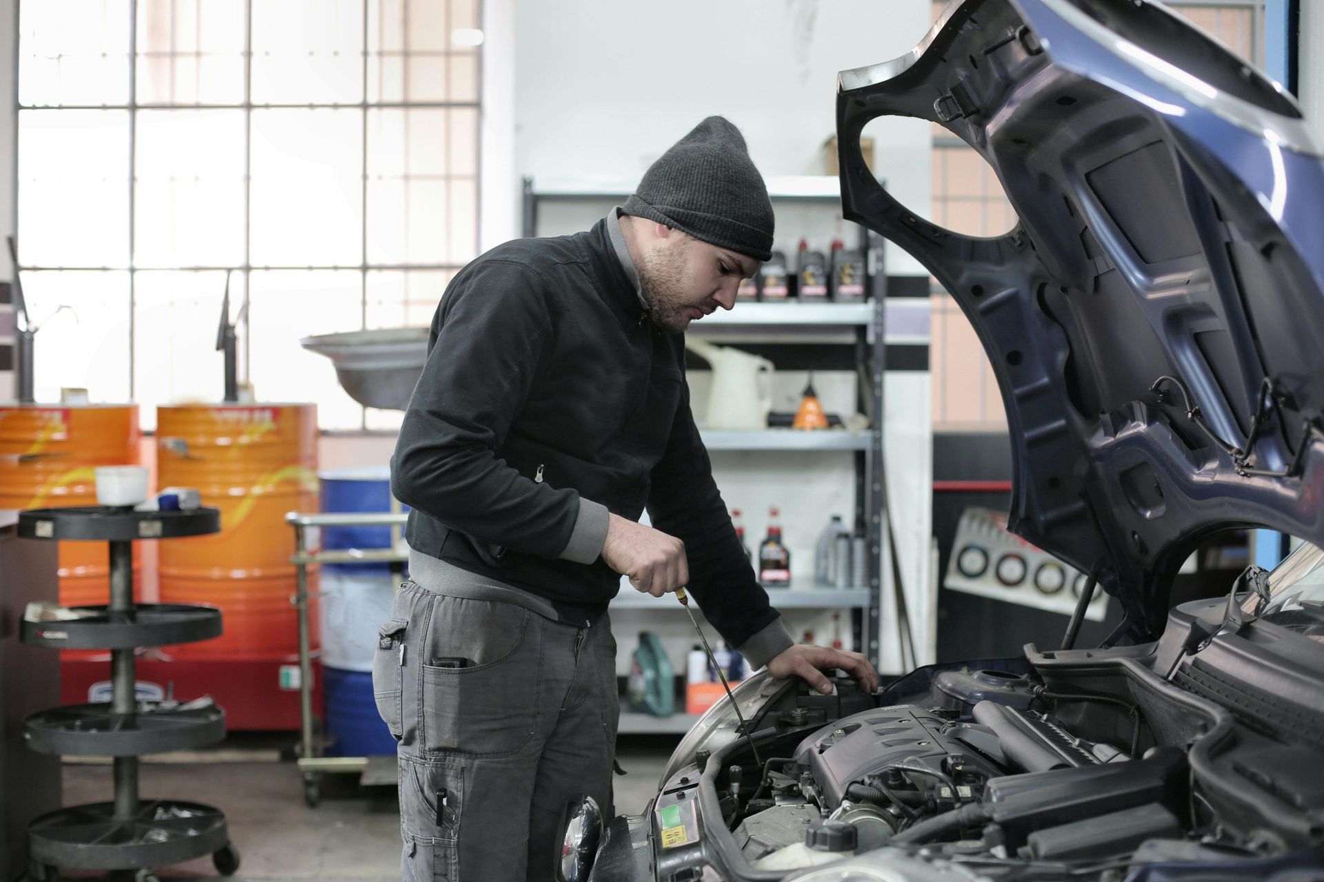Mechanic Checks the Oil of a Car in a Workshop — Ballina Automatics in Ballina, NSW