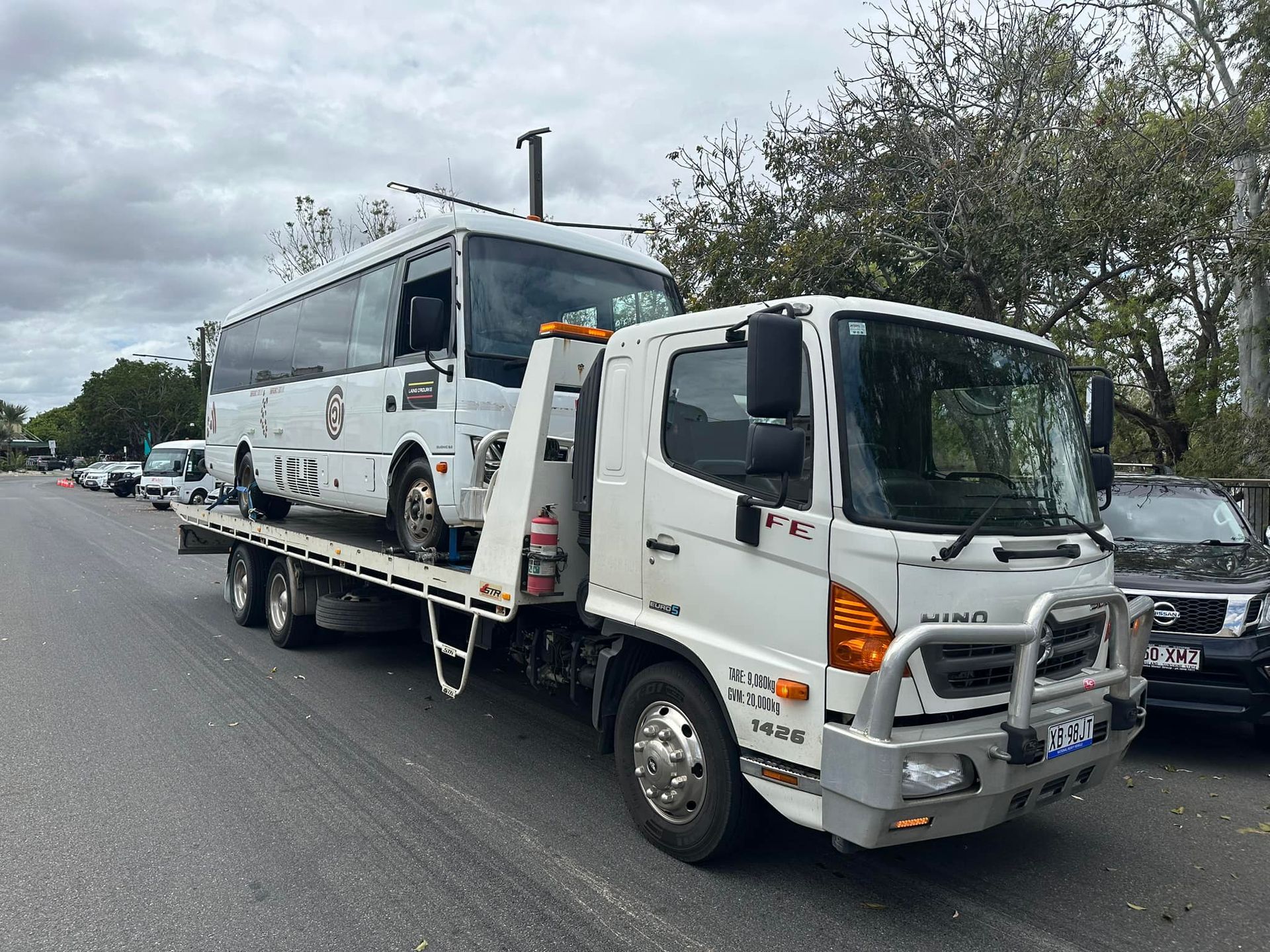 White Bus Being Towed by A White Tow Truck on A Road — Cq Towing Services In Rockhampton City, QLD