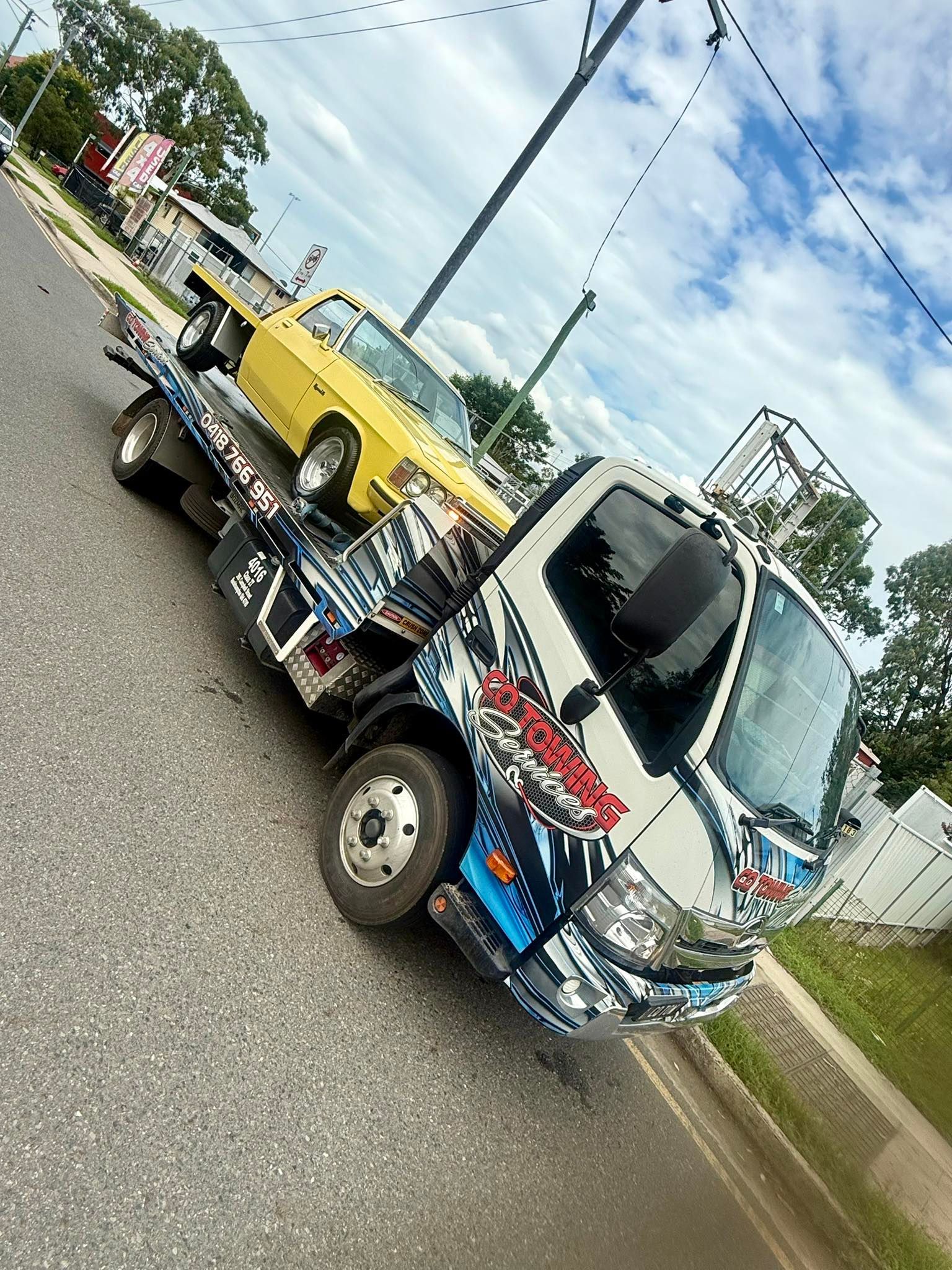 White Flatbed Truck Carrying Wooden Pallets in An Outdoor Setting — Cq Towing Services In Rockhampton City, QLD