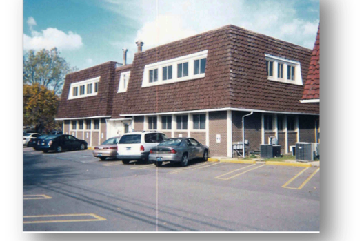A Picture Of A Building With Cars Parked In Front Of It
