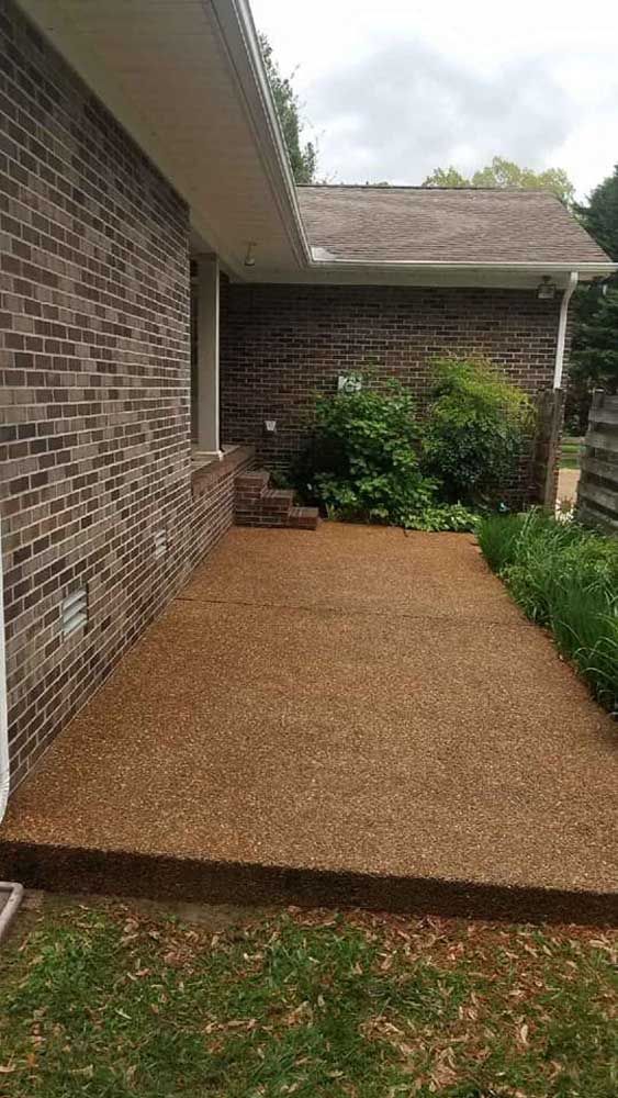 A brick house with a gravel walkway leading to it.