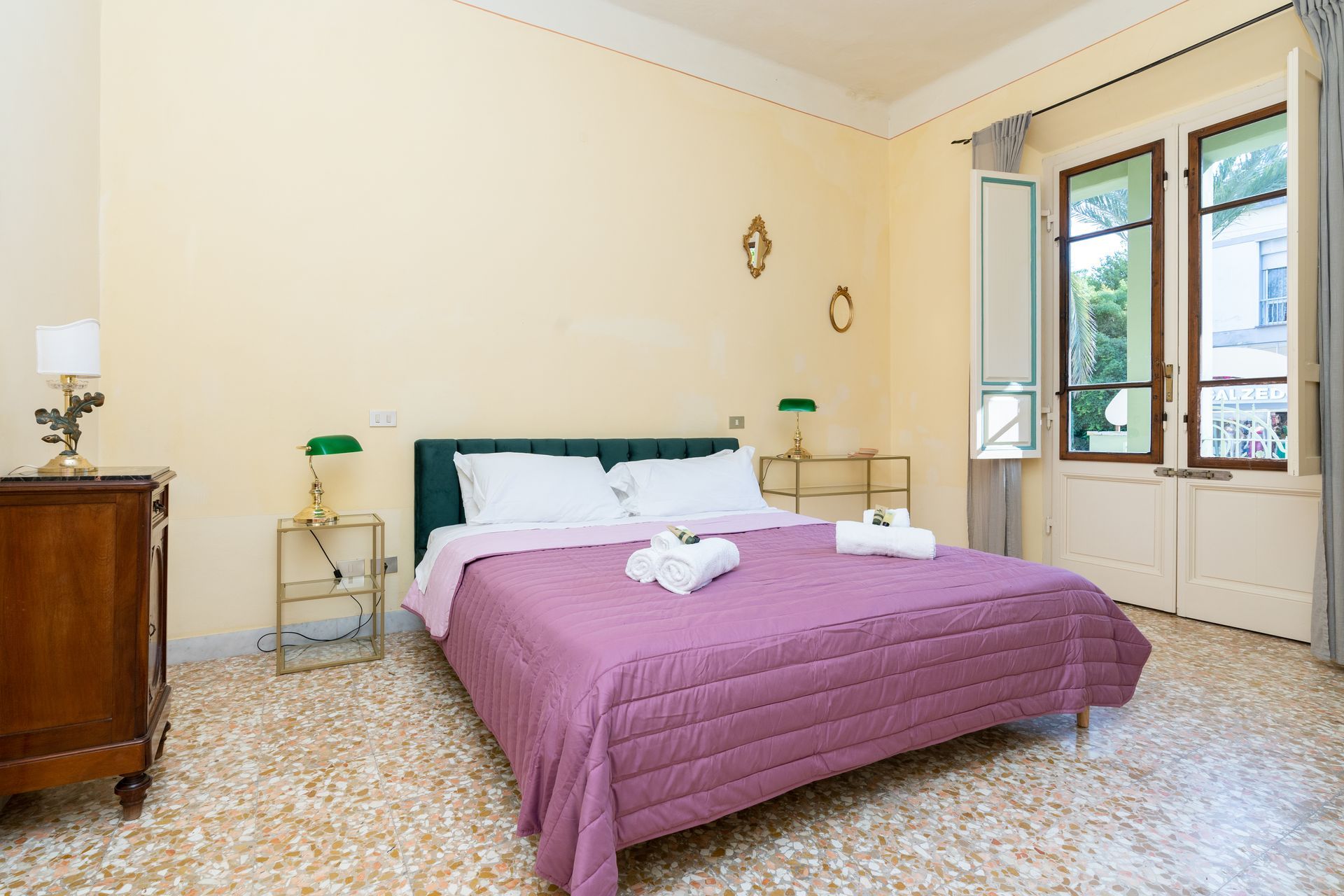 Bedroom with double bed, dresser, and a window with natural light.