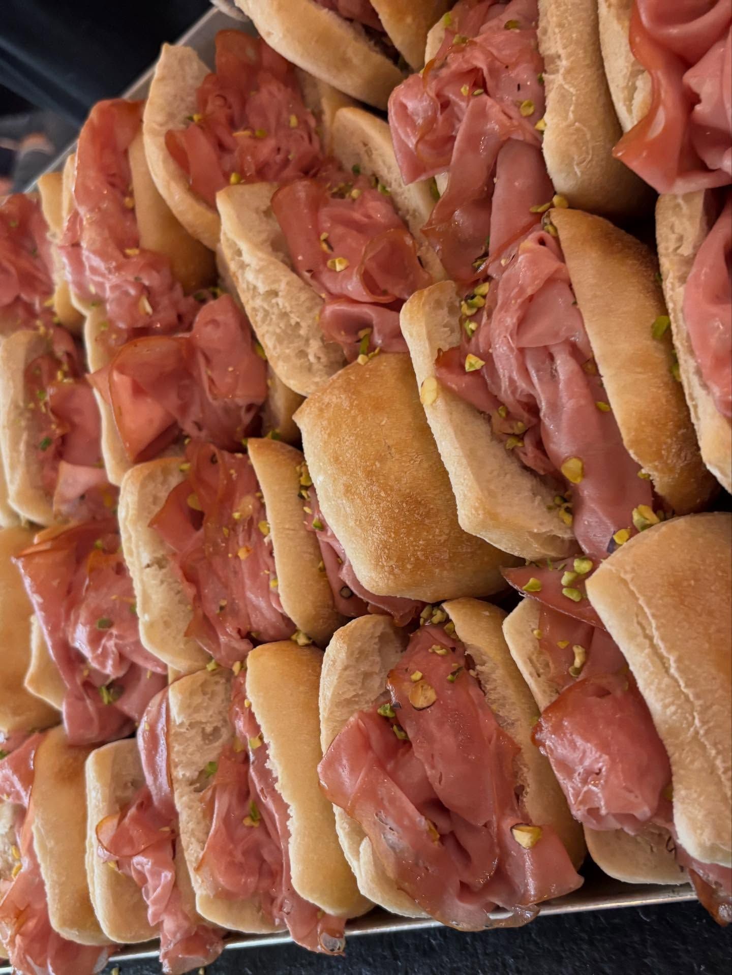 Vassoio di tramezzini affettati ripieni di prosciutto rosa e senape