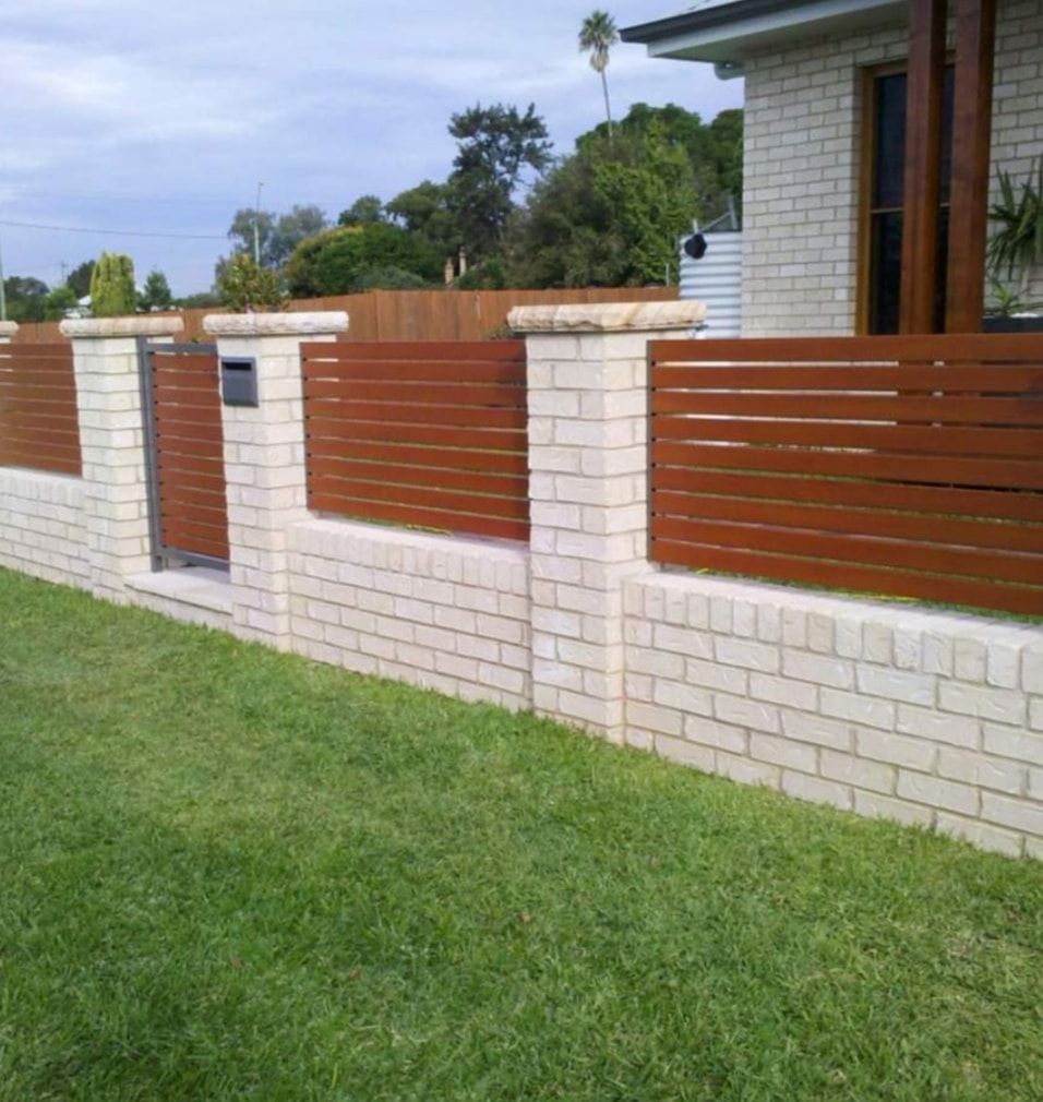 Brick And A Wooden Colored Fence In Front Of A House — Decorative Aluminium Works In Maitland, NSW