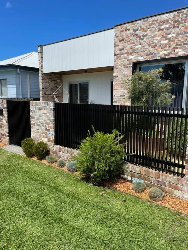 Brick House With A Black Stylised Fence And A Lush Green Lawn — Decorative Aluminium Works In Hunter Valley, NSW