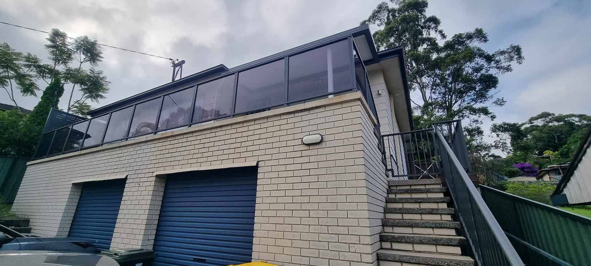 A White Brick House With Stairs Leading Up To It — Decorative Aluminium Works In Port Stephens, NSW