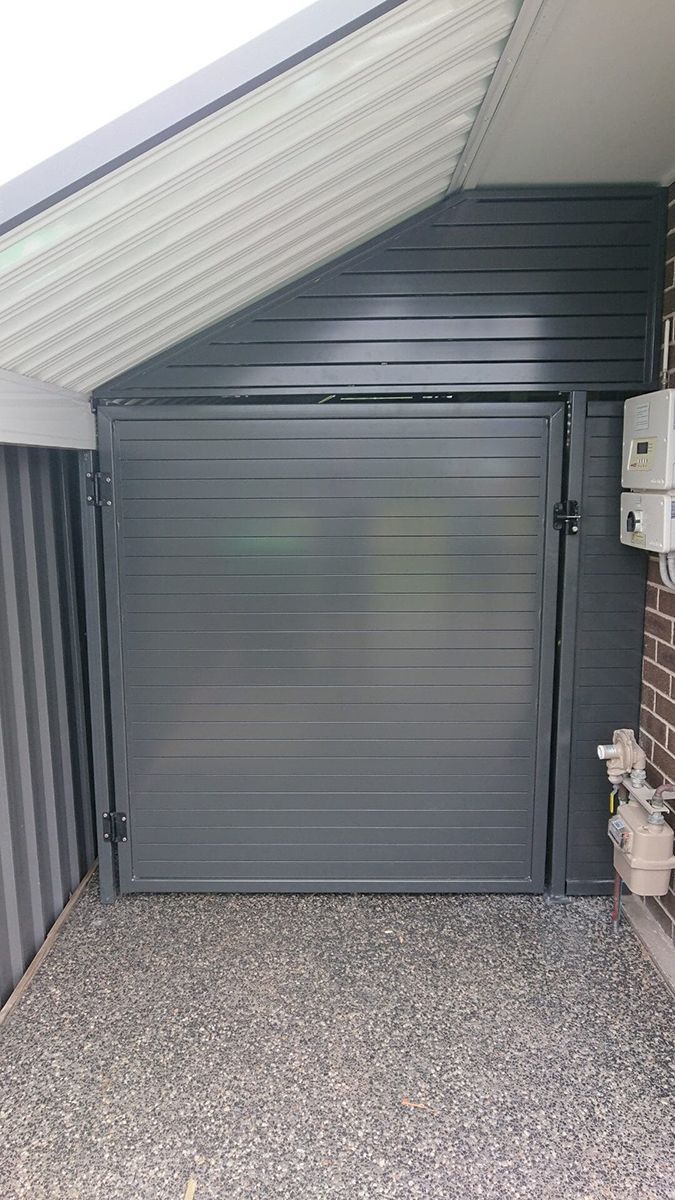 Gray Aluminium Garage Door Under A Slanted Roof — Decorative Aluminium Works In Cardiff, NSW
