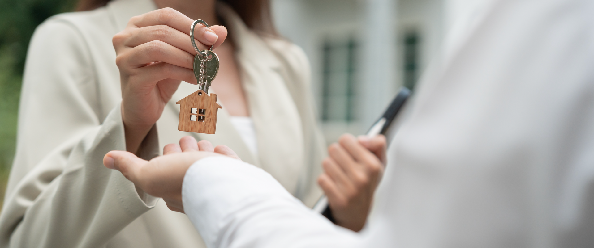 A man is handing a woman a set of house keys.