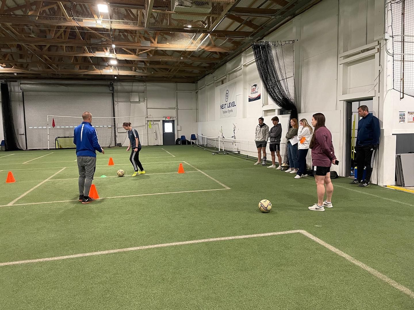 A group of people are playing soccer in an indoor stadium.