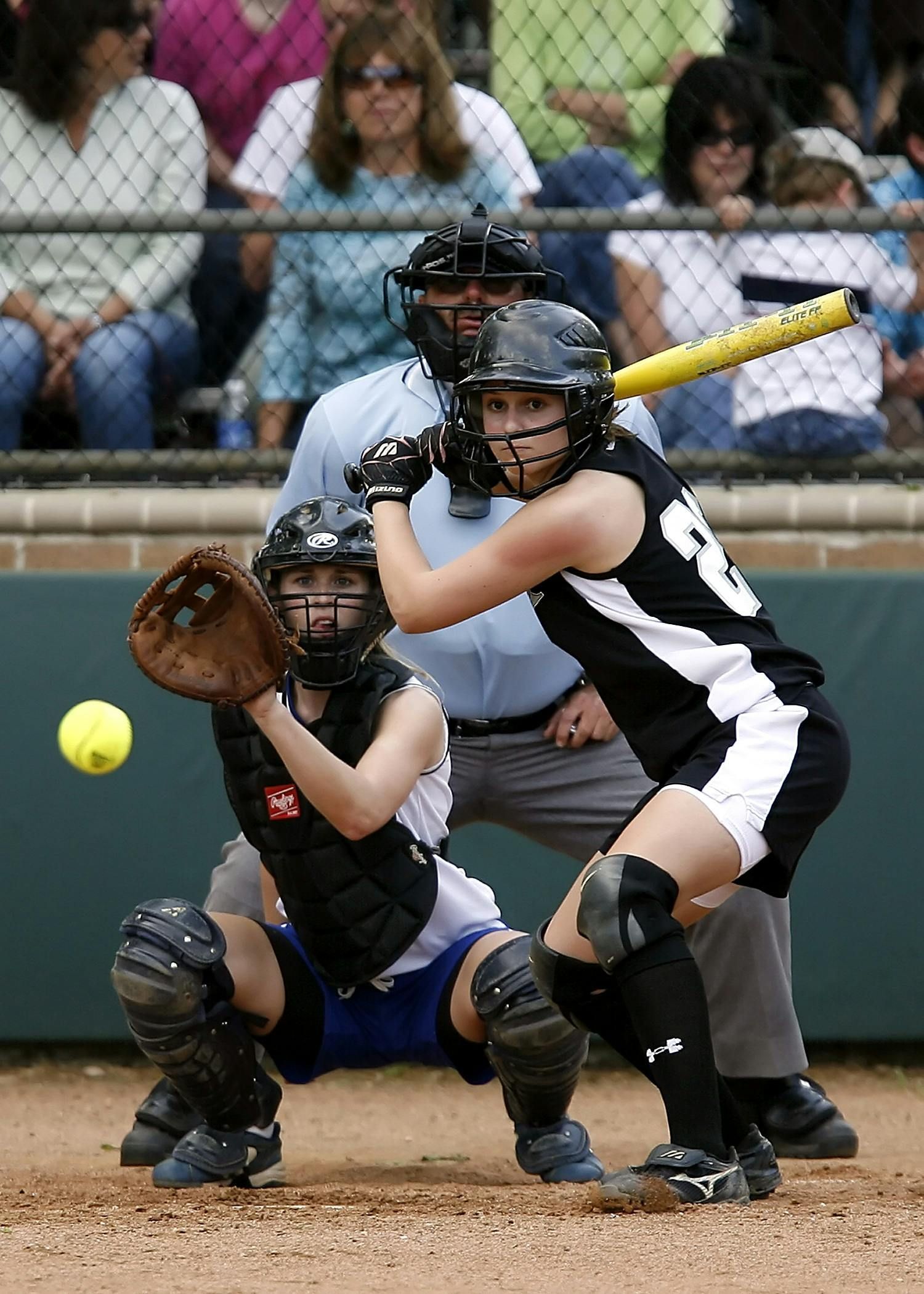 A girl with the number 3 on her jersey is playing softball