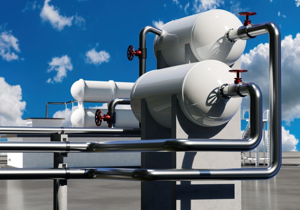 A bunch of pipes are connected to a building with a blue sky in the background.