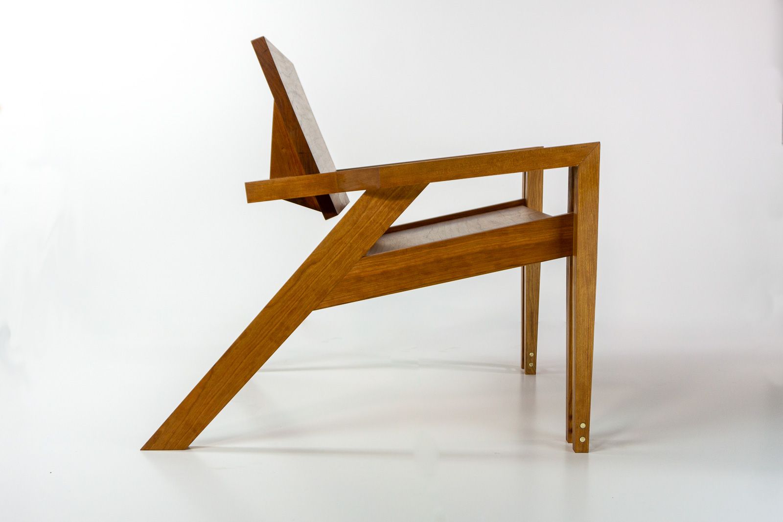 Cherry lounge chair in profile, showing its cantilevered angled leg and low reclined stance. Ames, Iowa.