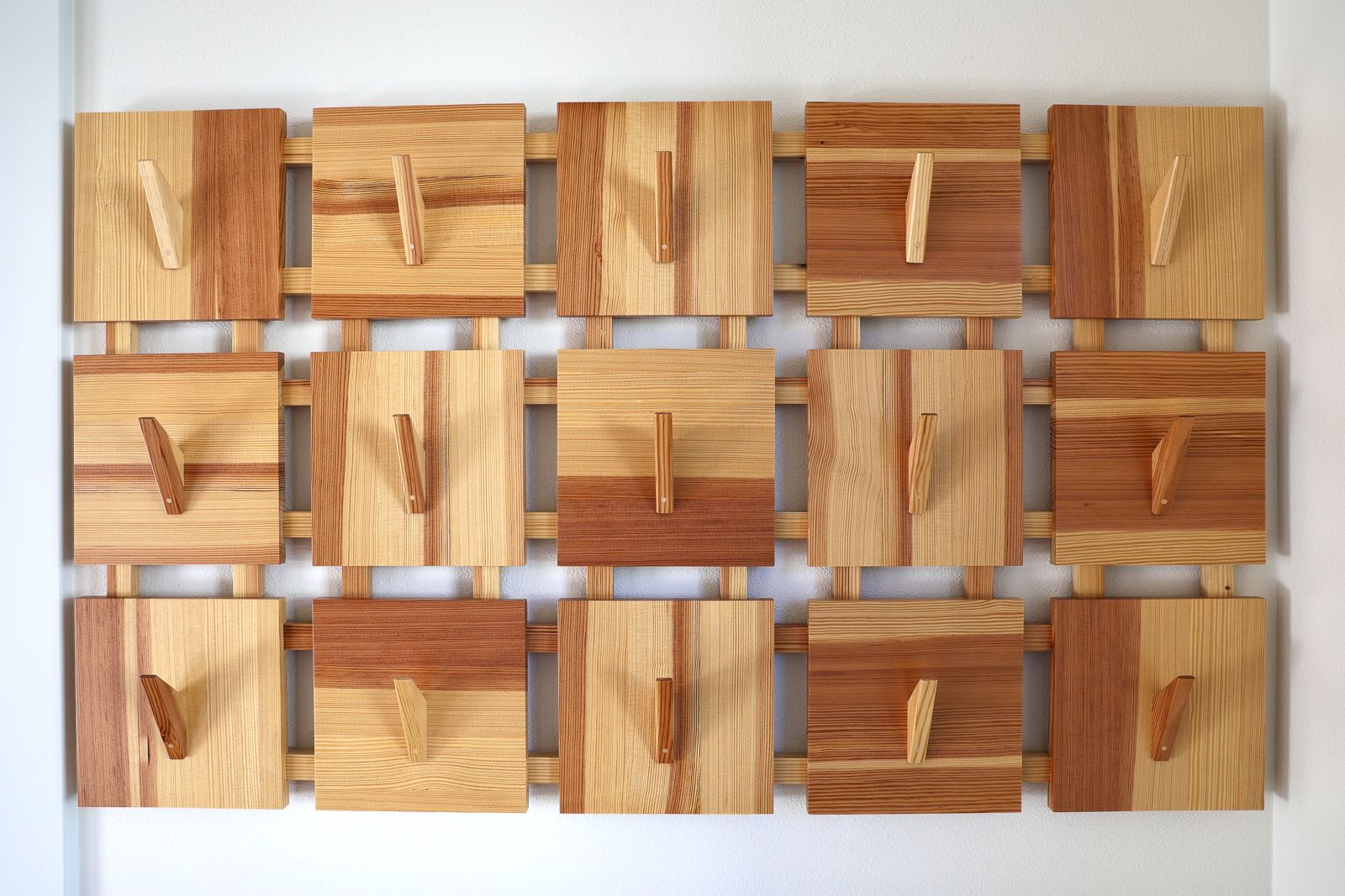 Array coat rack in reclaimed Douglas fir, an even grid of angular hooks, wall mounted in Story City, Iowa.
