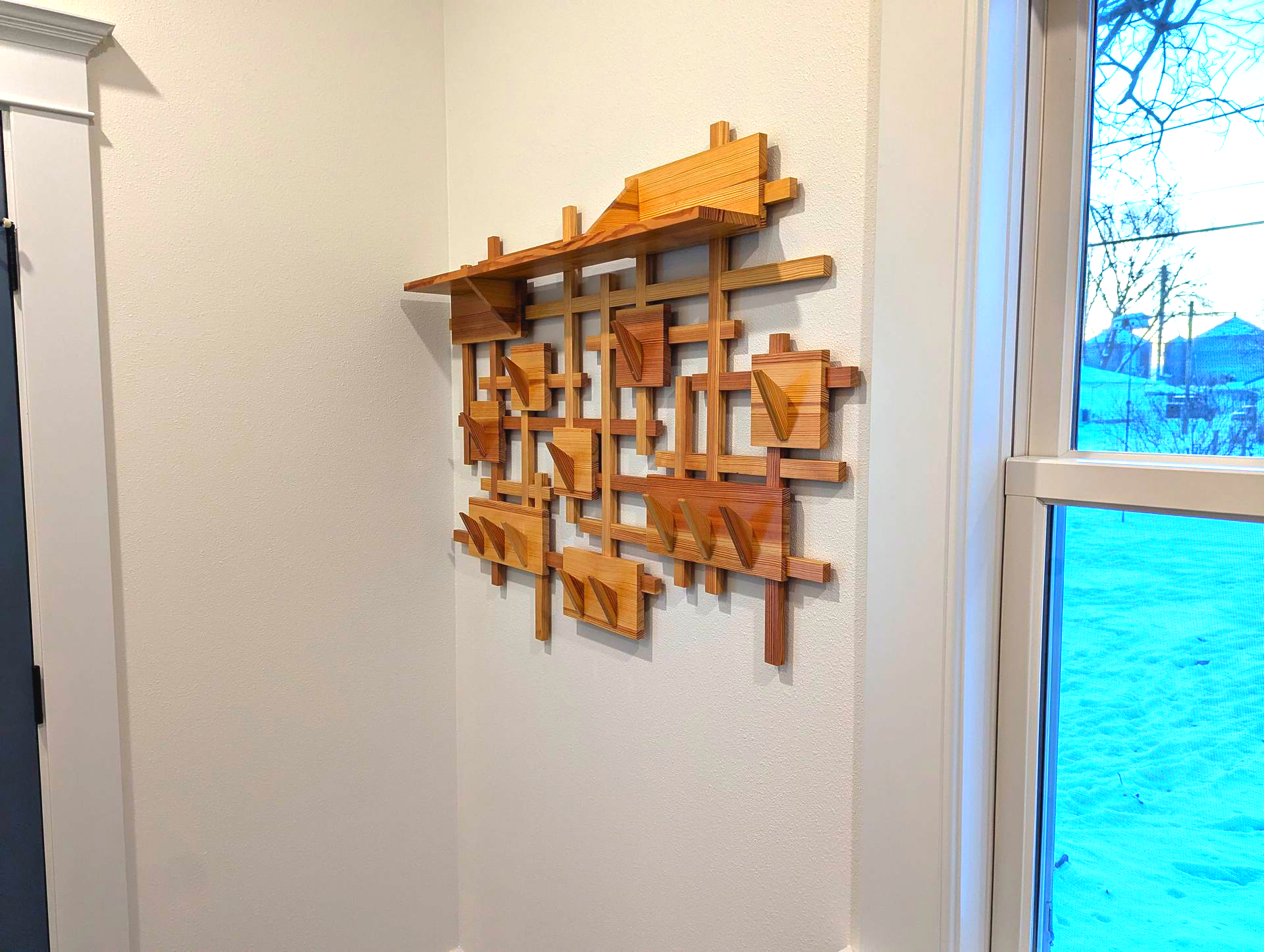 Geometric wall-mounted coat rack from reclaimed wood flooring, designed by Crow and Timber