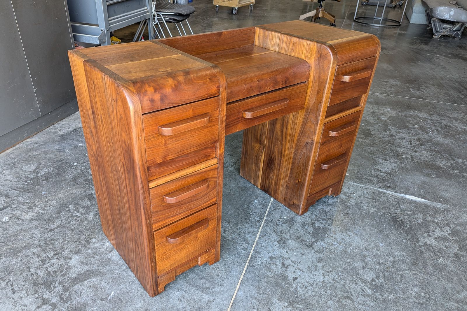 Walnut desk with rounded waterfall edges and curved drawer banks, art deco styling. Ames, Iowa.