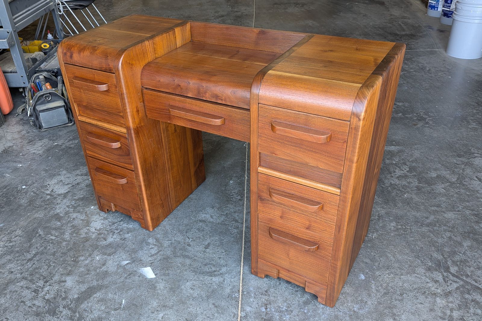 Walnut Deco desk, alternate view of the waterfall edges and curved drawer banks. Ames, Iowa.