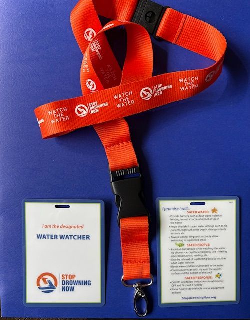 Red lanyard and badges with "Water Watcher" and "Stop Drowning Now" logos.