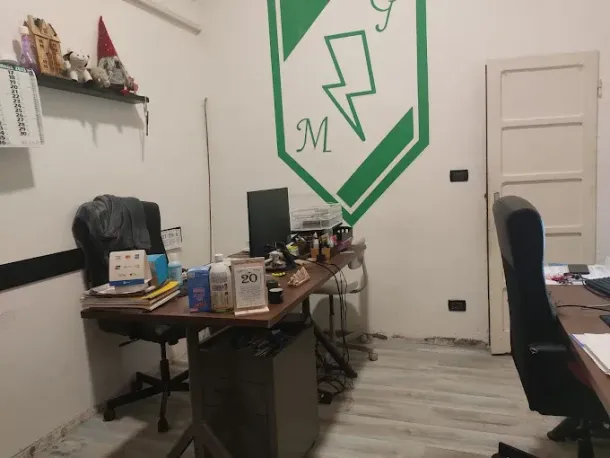 Tecnico al lavoro su un pannello di controllo in un impianto industriale, con pannelli e macchinari riflessi alle sue spalle.