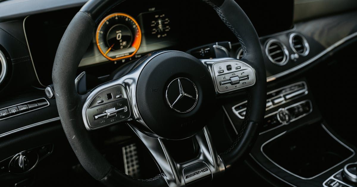 A close up of a mercedes benz steering wheel and dashboard.