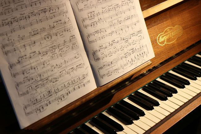 An acoustic piano with sheet music.