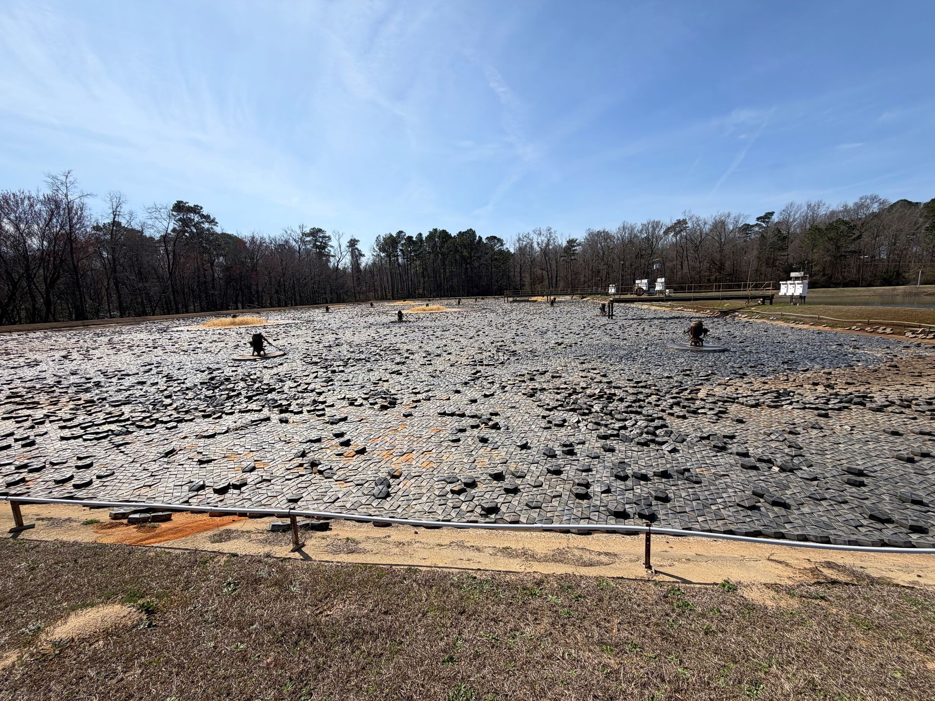 Before photo of aeration basin covered in hexagonal floating covers with decades of sludge underneath at a North Carolina wastewater facility