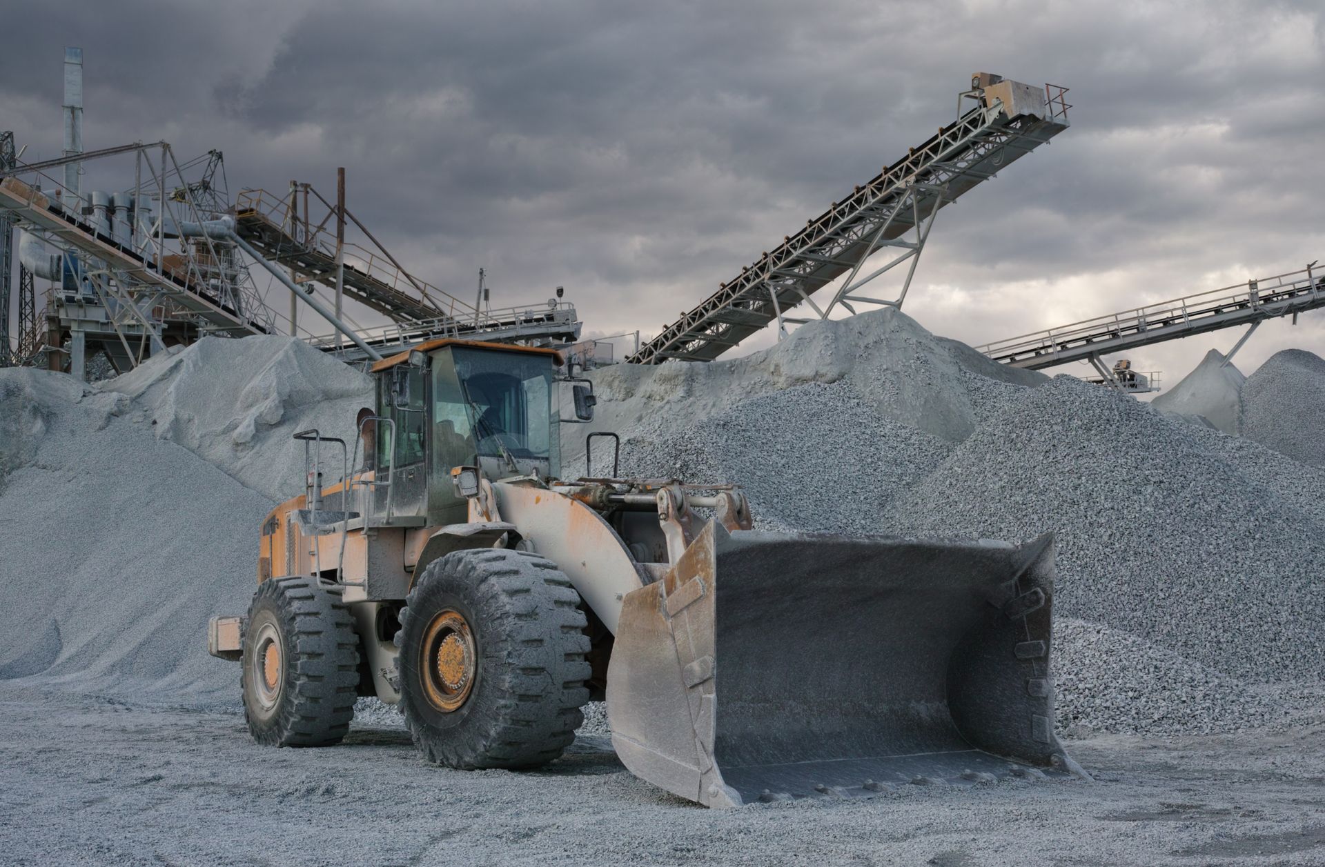 Wheel loader processing and reclaiming mineral materials at an active mining and mineral processing site