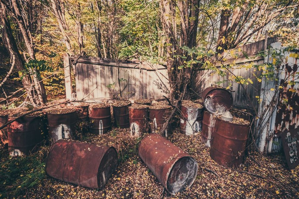 Abandoned site with deteriorating drums requiring hazardous waste identification, cleanup, and compliant disposal