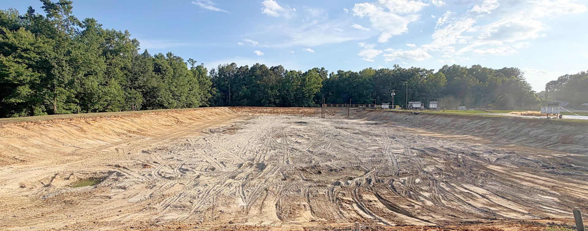 Cleared and regraded aeration basin ready for HDPE liner installation after 4,400-ton sludge removal in North Carolina