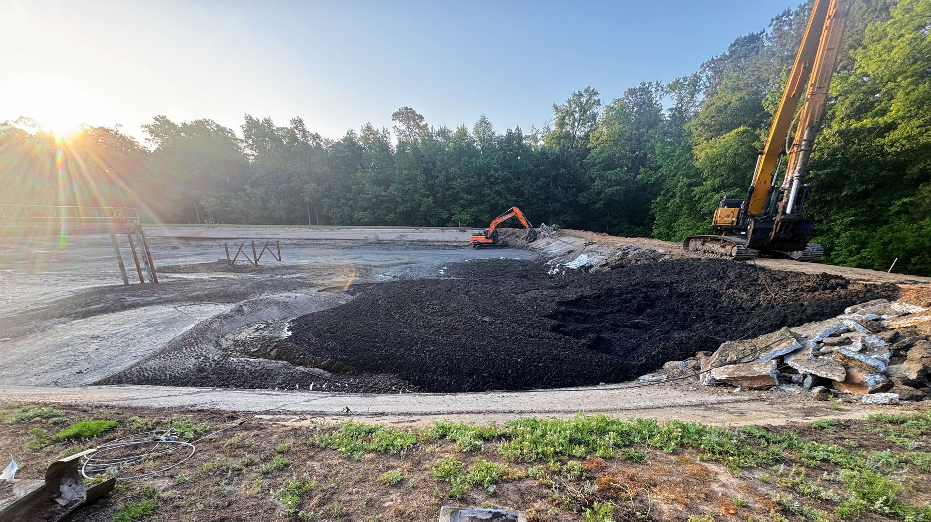 Excavator working alongside sludge during lagoon cleanout at a North Carolina wastewater treatment facility