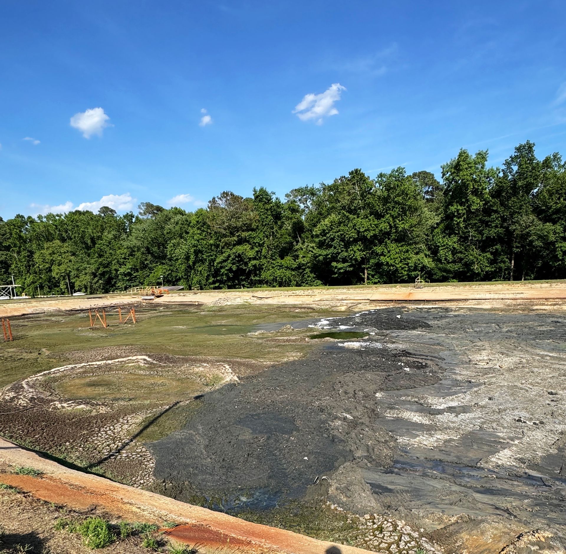 Dewatered aeration basin exposing decades of sludge accumulation before removal at a North Carolina wastewater treatment facility
