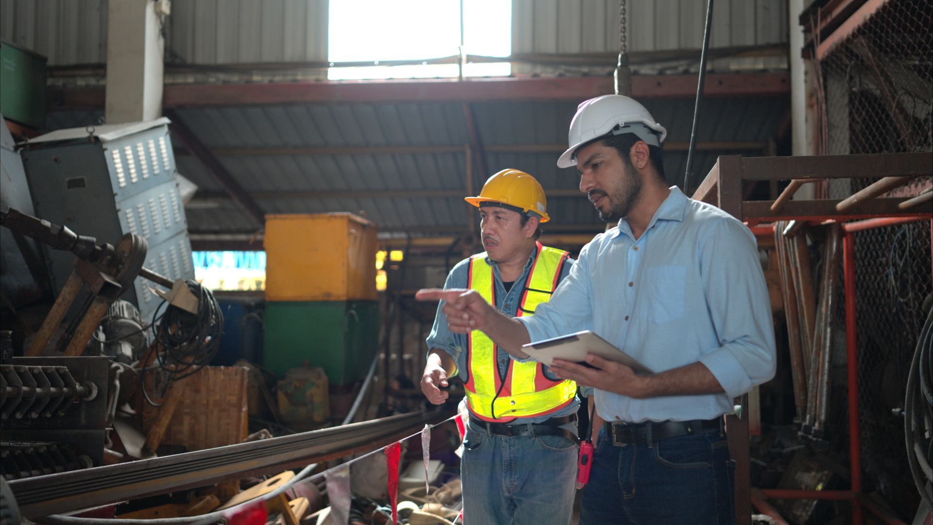 EHS managers reviewing waste characterization documentation and routing information at an industrial manufacturing facility