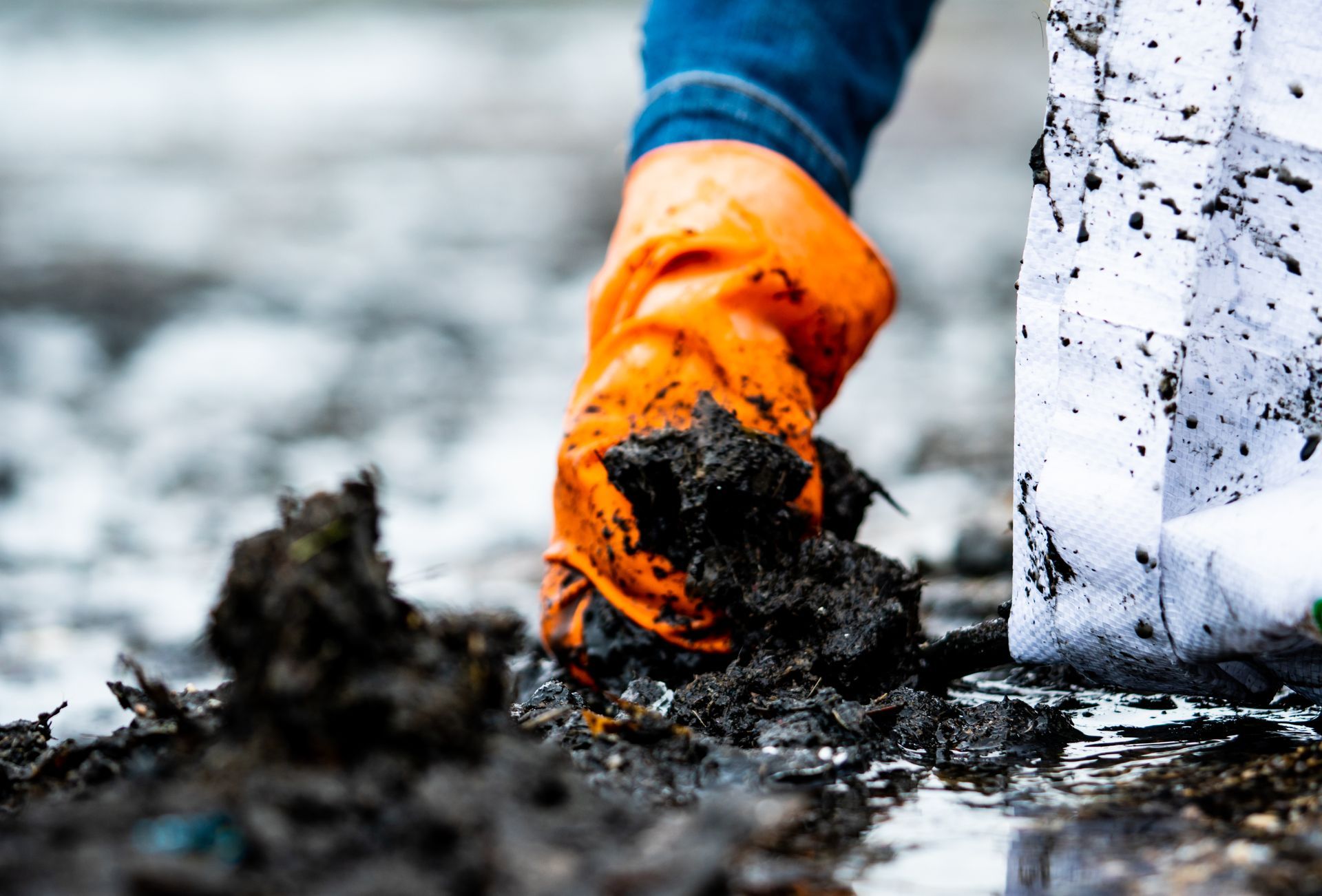 Technician collecting contaminated material during environmental site remediation and cleanup services