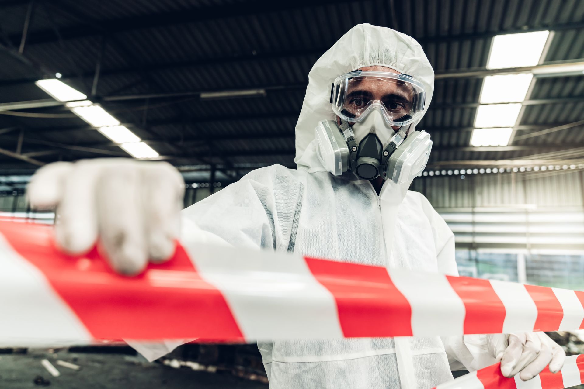 Hazmat technician securing contaminated area during licensed asbestos removal services